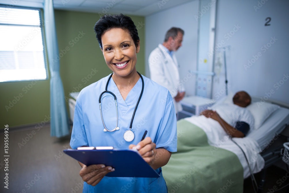 Portrait of female nurse writing on clipboard in ward Portrait of female nurse writing on clipboard in ward