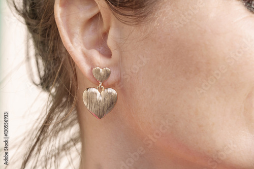 Fototapeta Woman wearing a heart shape earring
