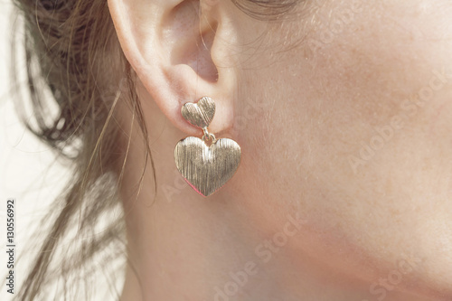 Woman wearing a heart shape earring photo