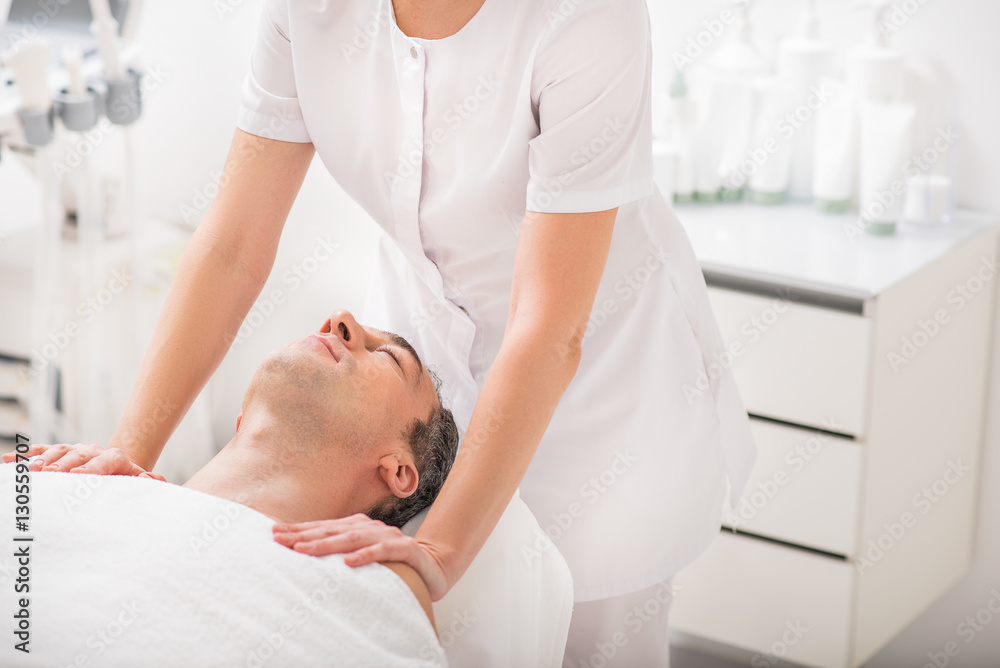 Relaxed male client enjoying massaging treatment