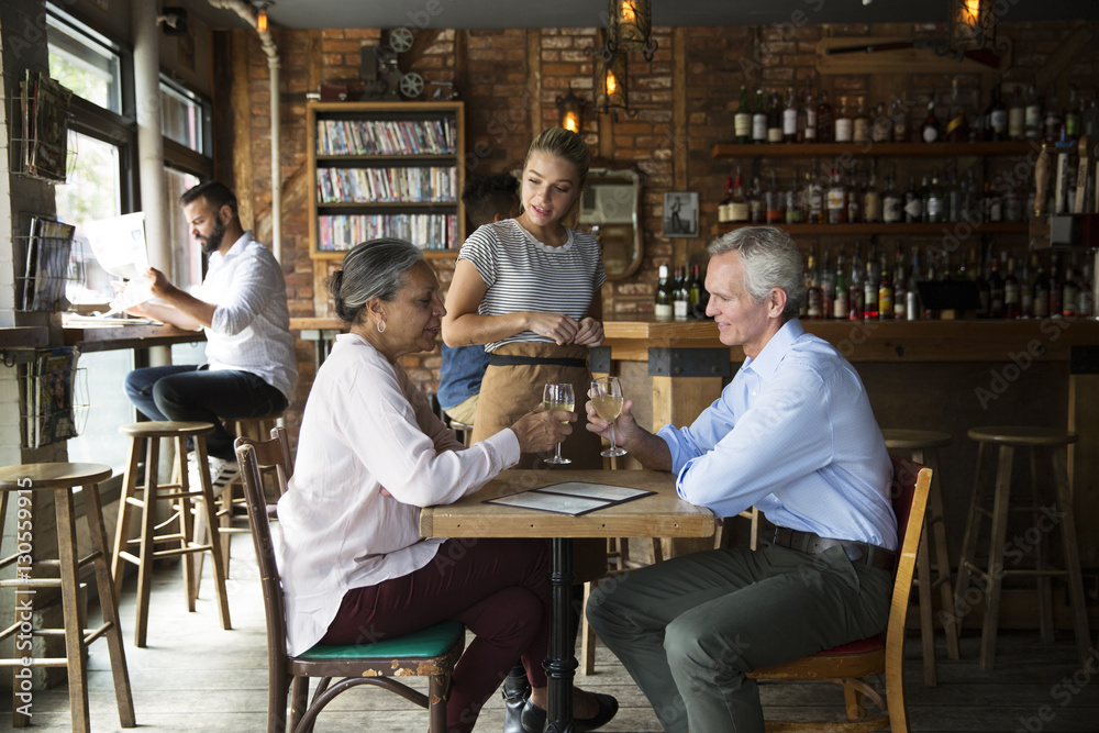 Waitress talking to customers sitting at cafe Waitress talking to customers sitting at cafe