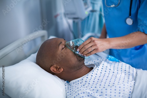 Nurse adjusting oxygen mask on patient mouth