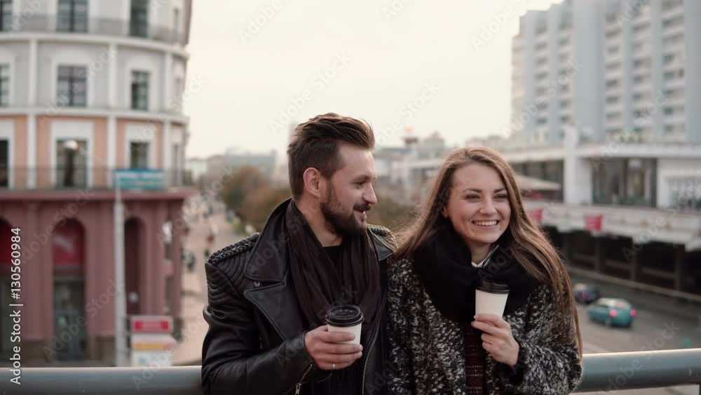 Young handsome man and a beautiful young brunette girl laughing emotionally, having takeaway coffee. Young handsome man and a beautiful young brunette girl laughing emotionally, having takeaway coffee.