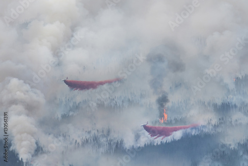 High angle view of seaplane discharging water on forest fire