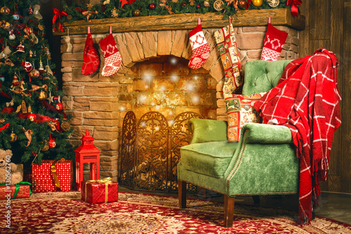 Christmas room with fireplace, an armchair and a Christmas tree with gifts