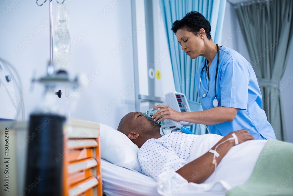 Nurse adjusting oxygen mask on patient mouth Nurse adjusting oxygen mask on patient mouth