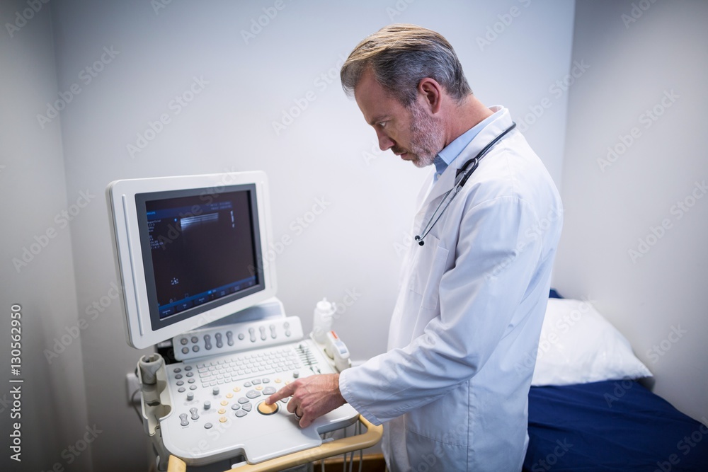 Doctor using patient monitoring machine in ward