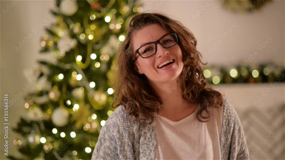 Portrait of Beautiful Young Woman with Attractive Smile in Glasses. Pretty Girl with Long Hair Looking at Camera and Smiling on Christmas Tree Background.. Portrait of Beautiful Young Woman with Attractive Smile in Glasses. Pretty Girl with Long Hair Looking at Camera and Smiling on Christmas Tree Background..