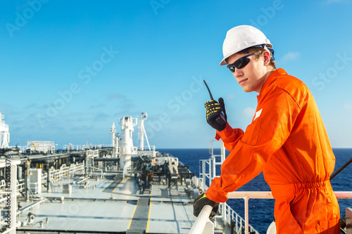 Deck officer using radio on the board of a tanker.