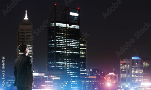 Businessman viewing night glowing city