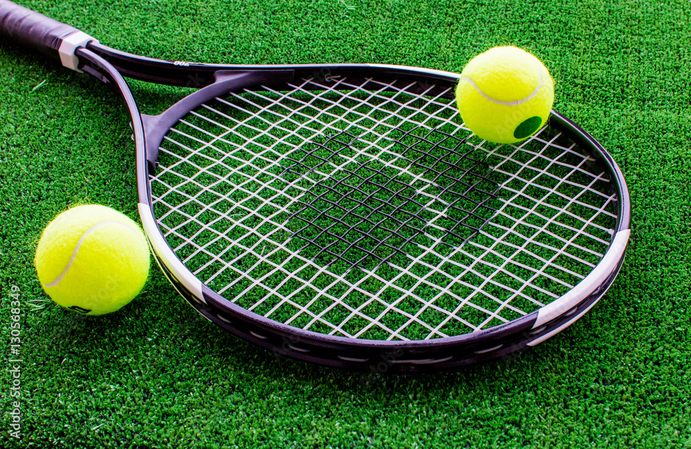 tennis racket on green background close up