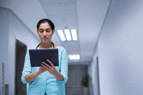 Female doctor using digital tablet in corridor