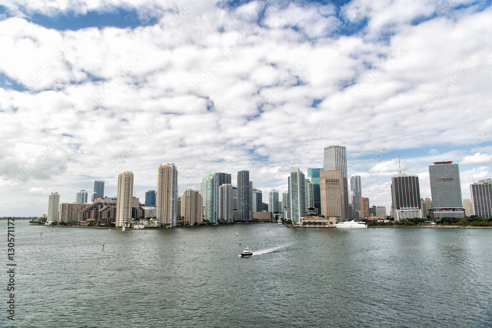 Aerial view of Miami skyscrapers with blue cloudy sky, boat sail