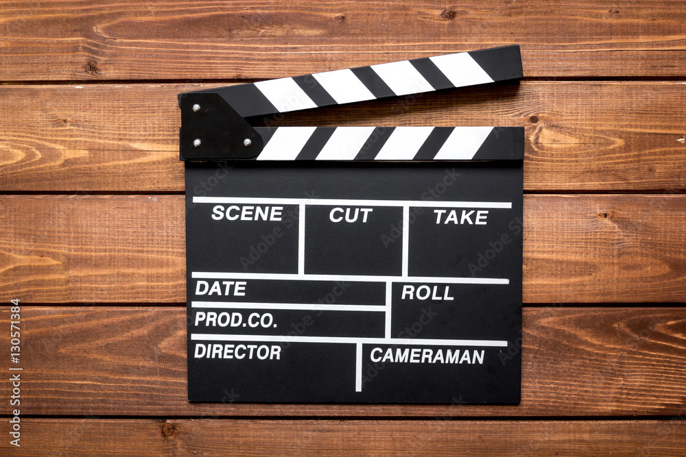 Obraz premium Screenwriter desktop with movie clapper board wooden background top view