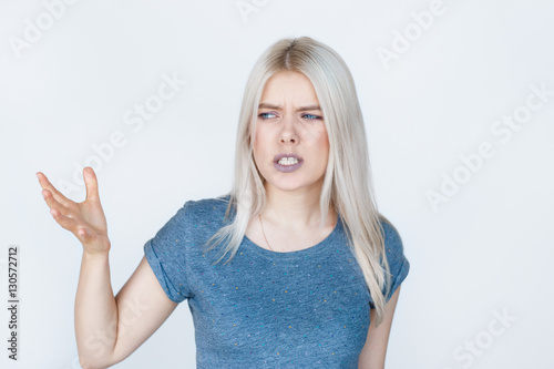 Discontent young woman on white background.