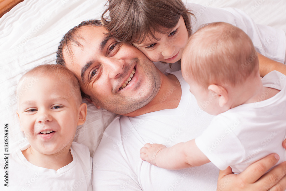 Portrait of a father with children on the bed Portrait of a father with children on the bed