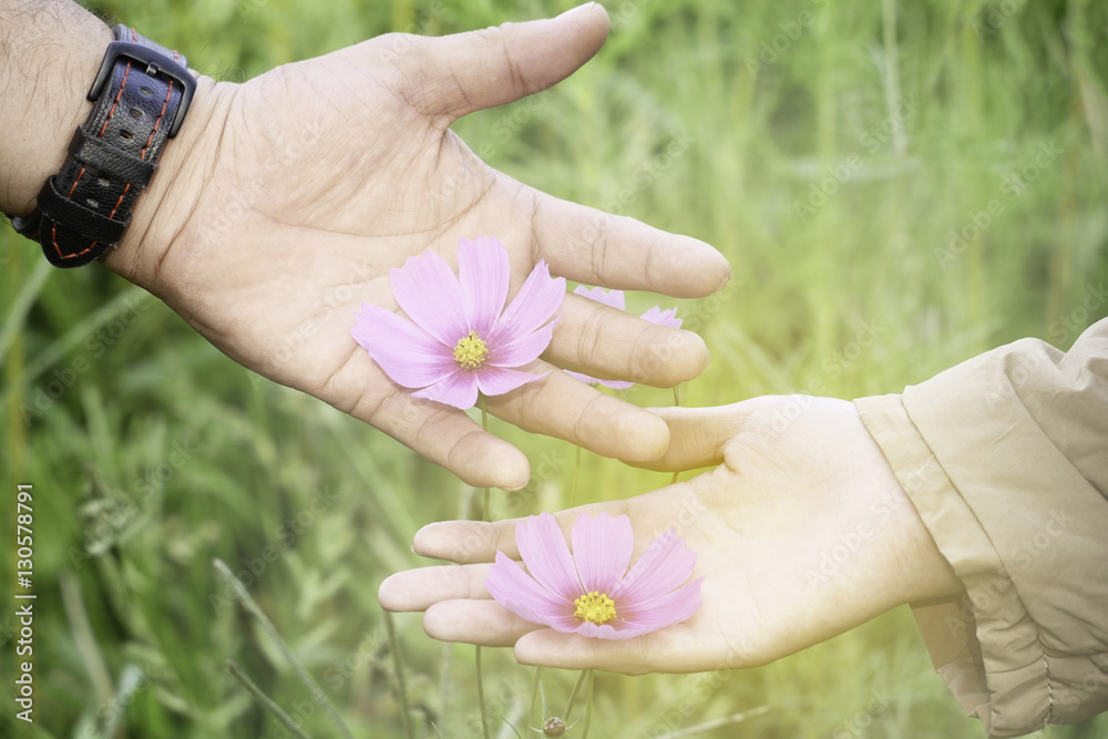 Couple, man and woman hold flowers together to present love to e Couple, man and woman hold flowers together to present love to e