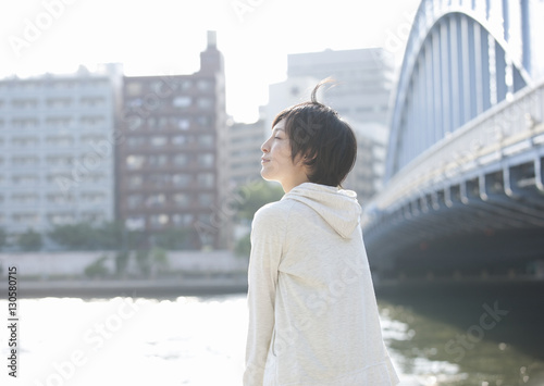 Young woman standing beside river