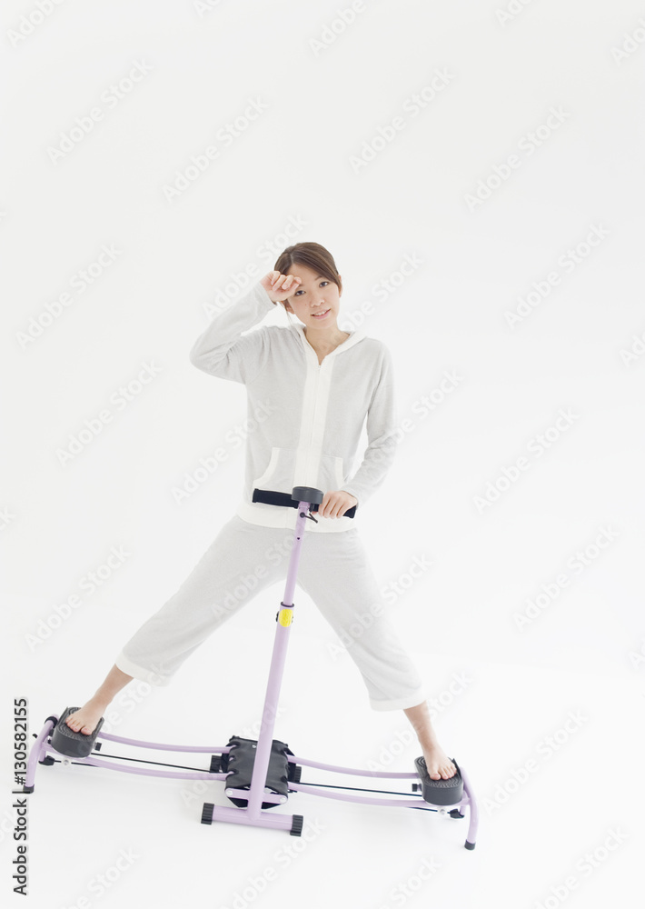 Young woman using leg machine
