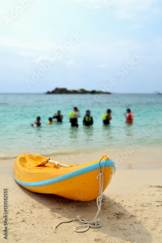 Yellow kayak on beach in evening day with blue sea background. © LittleGallery
