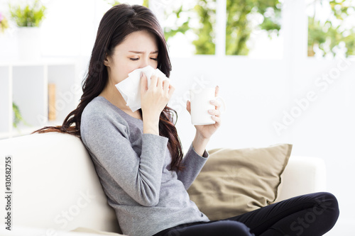 Young Woman Infected With Cold Blowing Her Nose