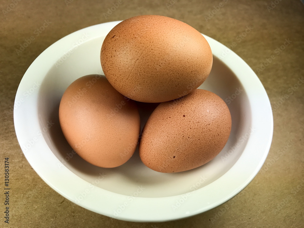 Fresh eggs in a bowl, Brown background Fresh eggs in a bowl, Brown background