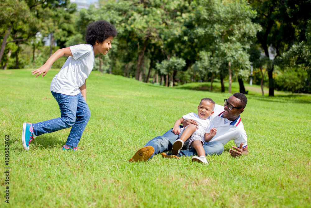 Two kids chasing and playing together while dad caught a boy in park Two kids chasing and playing together while dad caught a boy in park