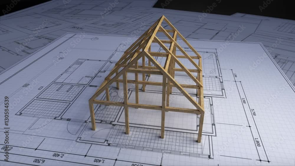 Wood frame making house on architectural design plan paper.
