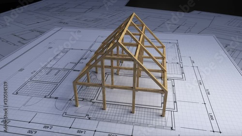 Wood frame making house on architectural design plan paper.