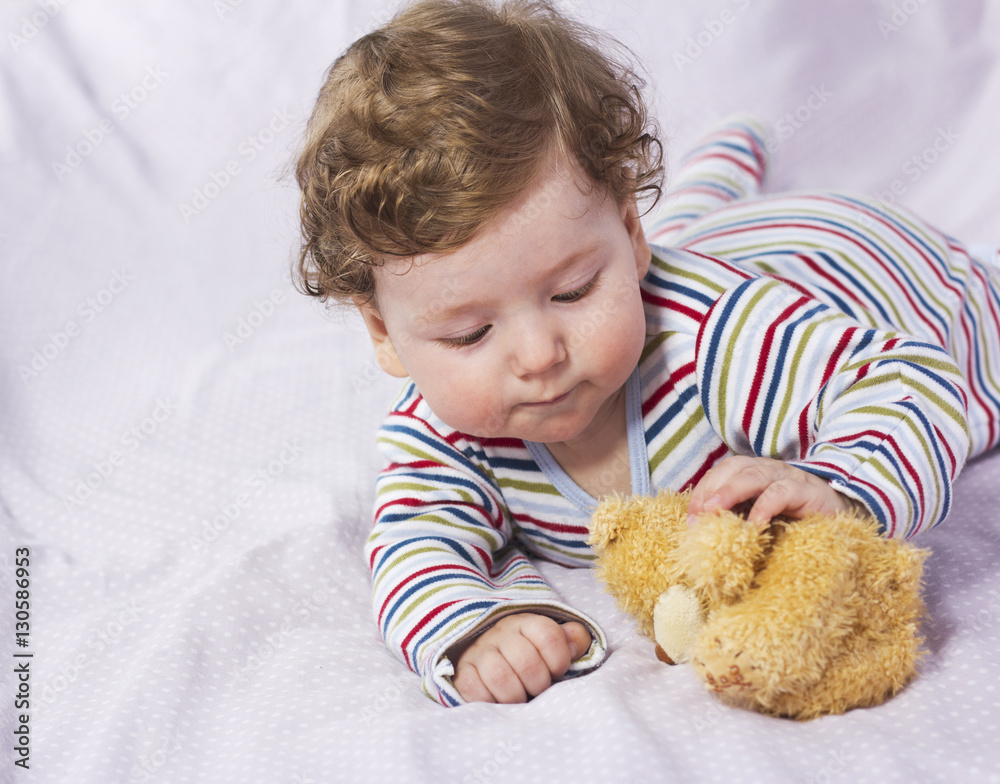 The little boy in the crib with toys. The child in the home
The little boy in the crib with toys. The child in the home