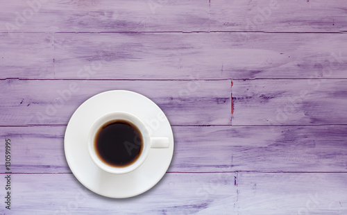 Top view of coffee cup on purple wooden background