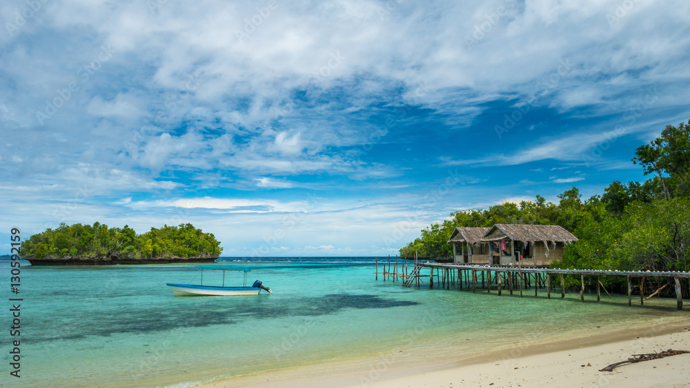 Beautiful Blue Lagoone with some Bamboo Huts, Kordiris Homestay, Palmtree in Front, Gam Island, West Papuan, Raja Ampat, Indonesia