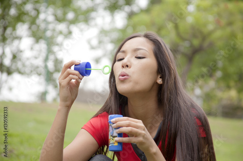Young woman playing with soap bubbles