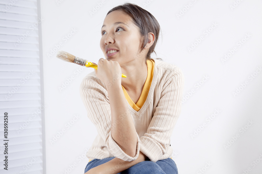 Young woman holding a painting brush Young woman holding a painting brush