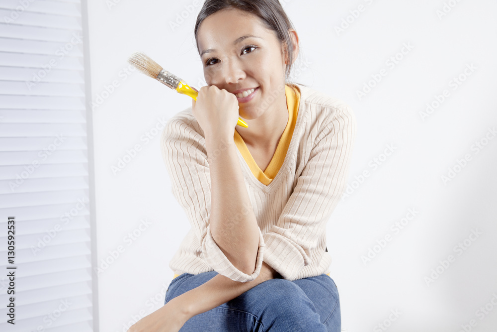 Young woman holding a painting brush Young woman holding a painting brush