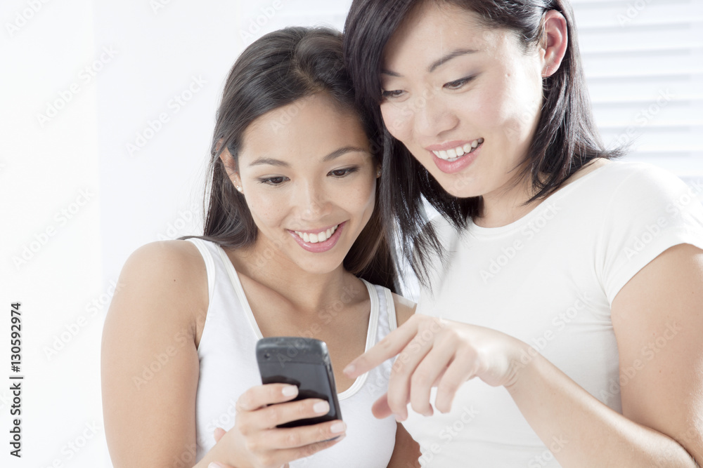 Young women looking at a cell phone Young women looking at a cell phone