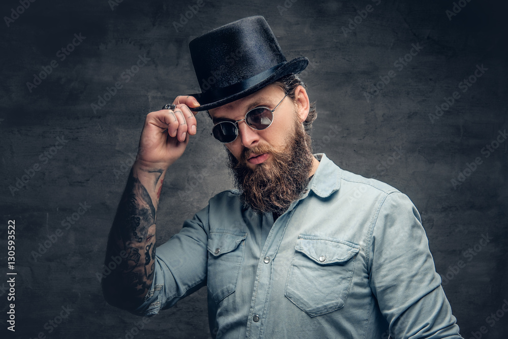 Bearded male in sunglasses and cylinder hat.