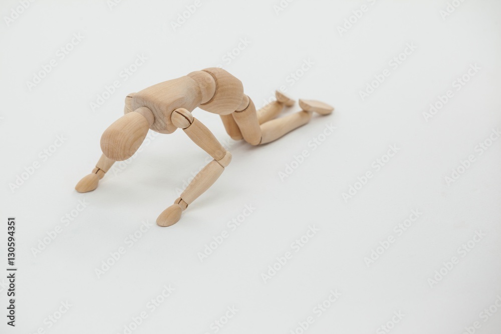 Wooden figurine exercising on floor Wooden figurine exercising on floor