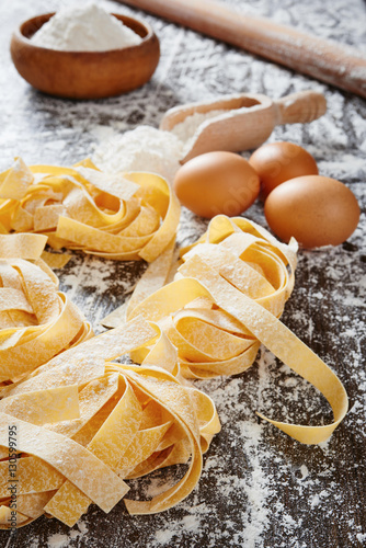 Fresh pasta on wooden table, flour and egg