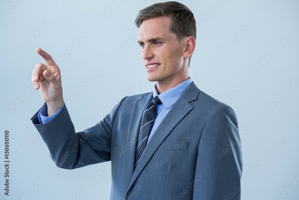 Smiling businessman touching an invisible screen Smiling businessman touching an invisible screen
