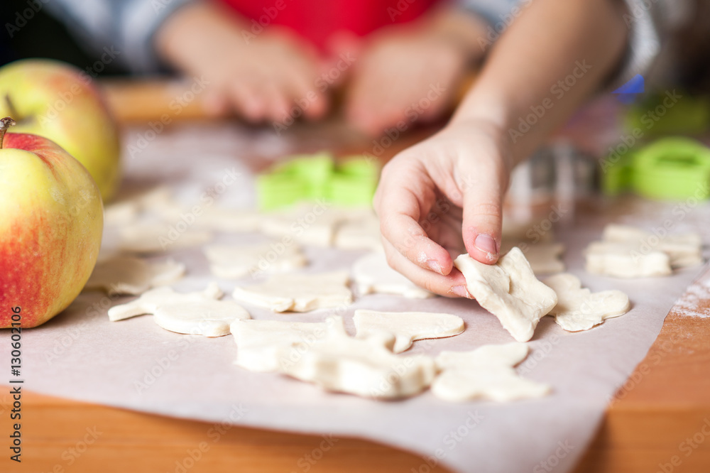 Kids baking cookies in the kitchen and decorate cookies on Christmas Eve Kids baking cookies in the kitchen and decorate cookies on Christmas Eve