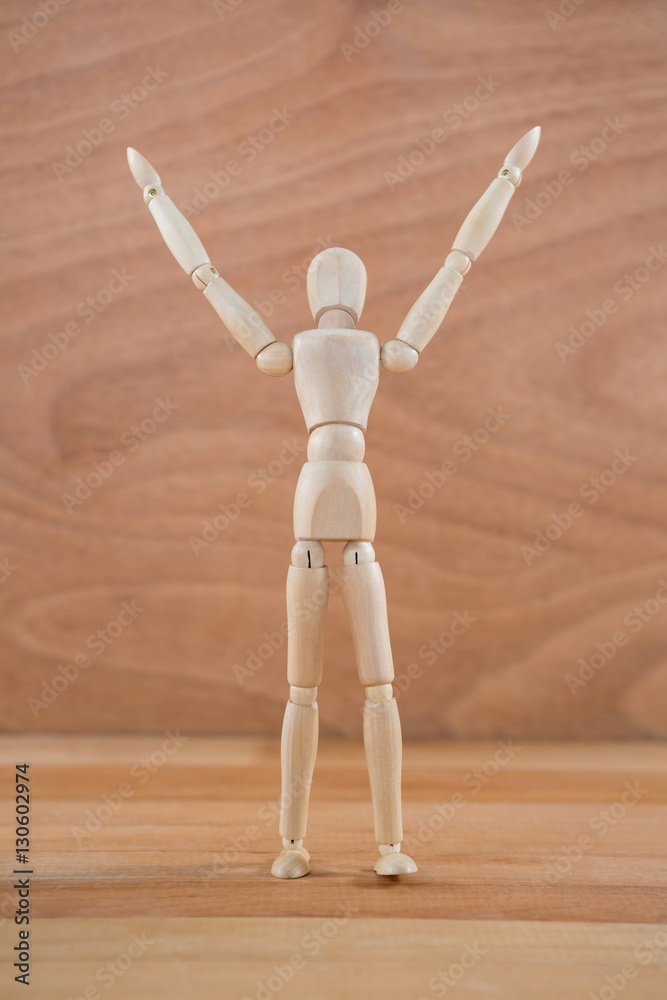 Wooden figurine standing with hand raised Wooden figurine standing with hand raised