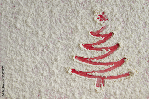 Christmas tree on flour background. White flour looks like snow.