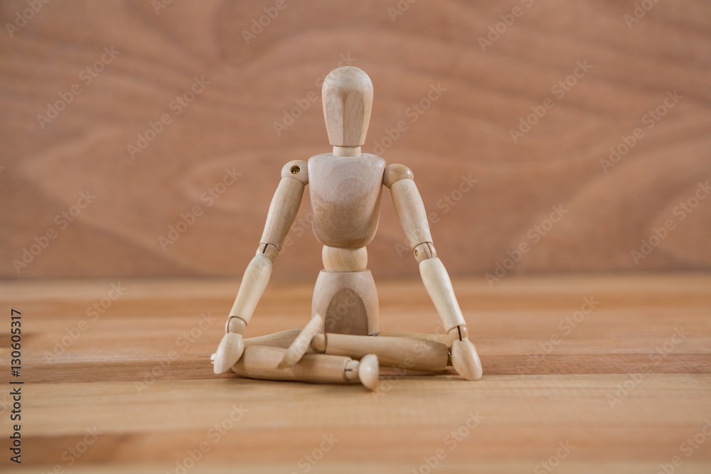 Wooden figurine sitting in a lotus position Wooden figurine sitting in a lotus position