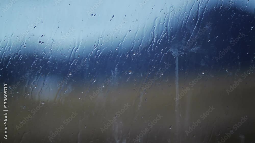 Blurred image of mountainson the background a rain spattered window glass