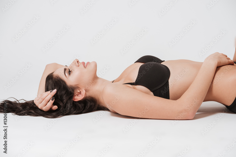 Fototapeta premium Beautiful woman in black lingerie laying on her back