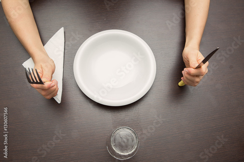 forchetta, coltello e piatto con mani in attesa di mangiare photo