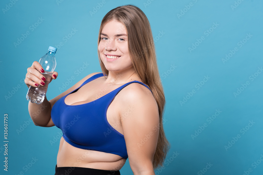 Pretty overweight lady holding bottle of water Pretty overweight lady holding bottle of water