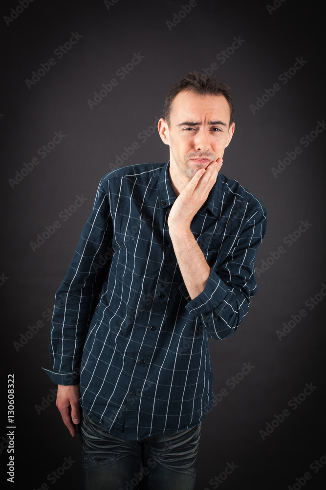 Handsome man doing different expressions in different sets of clothes: toothache Handsome man doing different expressions in different sets of clothes: toothache