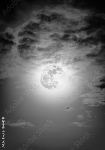 Nighttime sky with clouds and bright full moon with shiny.